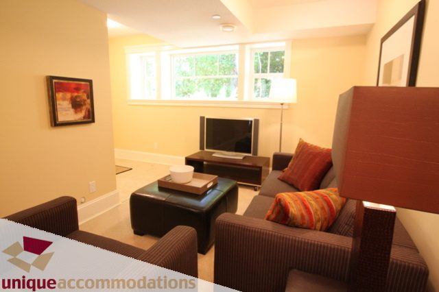 Bright living room with modern furniture and large windows. - 1287 Sinclair Court, West Vancouver