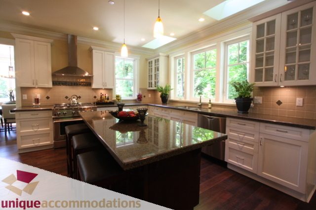 Bright kitchen with white cabinets, granite countertops, and hardwood floors. - 1287 Sinclair Court, West Vancouver