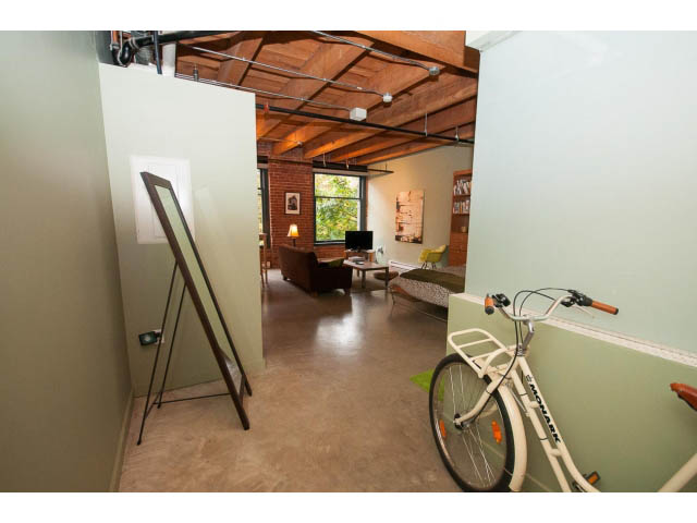 Loft with exposed ceiling beams, bike, and large windows. - 210 - 55 E Cordova St, Vancouver Downtown