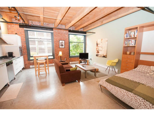 Furnished loft with hardwood floors, brick walls, and a city view. - 210 - 55 E Cordova St, Vancouver Downtown