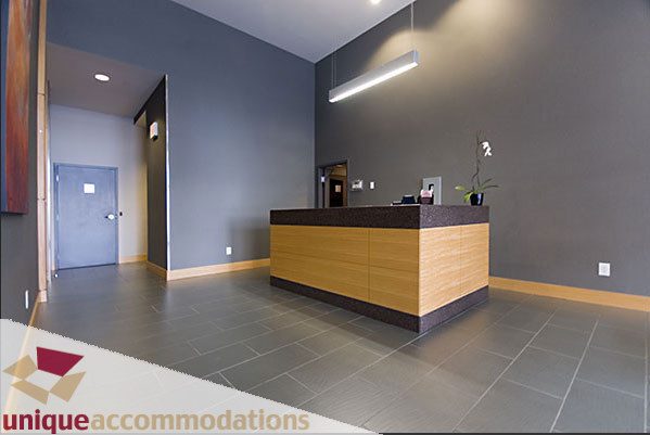 Modern reception area with wooden counter and sleek lighting. - 801- 628 Kinghorne Mews, Vancouver Downtown