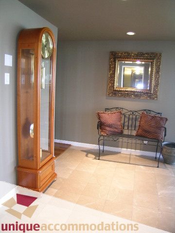 Furnished living room with a large grandfather clock and a decorative mirror. - 802-1590 West 8th Ave, Vancouver West Side