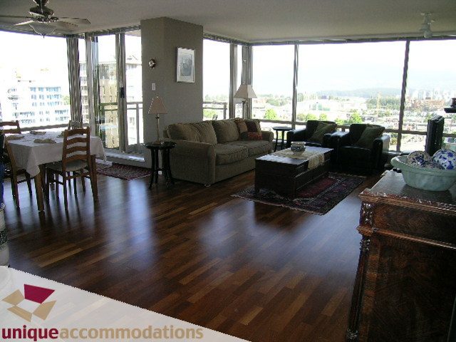 Spacious living room with hardwood floors, city view, and comfortable furnishings. - 802-1590 West 8th Ave, Vancouver West Side