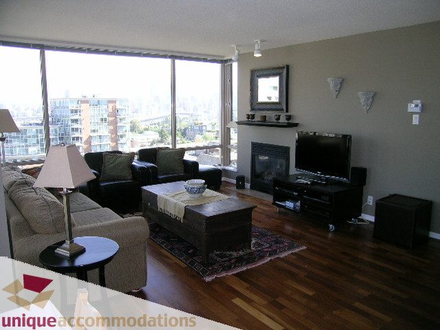 Furnished living room with hardwood floors, city view, and modern decor. - 802-1590 West 8th Ave, Vancouver West Side