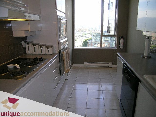 Bright kitchen with white countertops, city view, and modern appliances. - 802-1590 West 8th Ave, Vancouver West Side