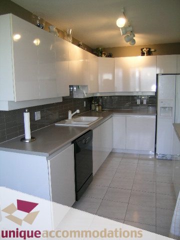 Bright kitchen with white cabinets, stainless steel appliances, and tiled flooring. - 802-1590 West 8th Ave, Vancouver West Side