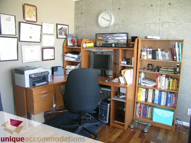 Furnished office with wooden shelves, desk, and computer setup. - 802-1590 West 8th Ave, Vancouver West Side
