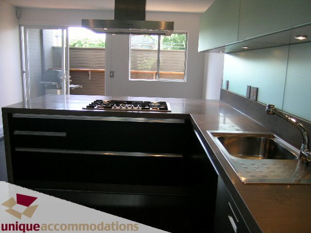 Bright kitchen with modern black island, stainless steel countertops, and large window view. - 1946 Mcnicoll Avenue, Vancouver West Side