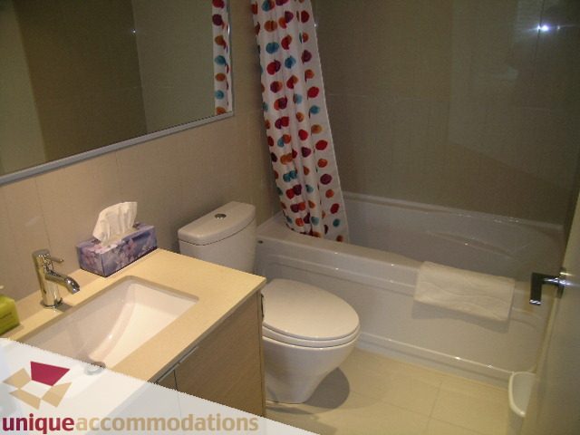 Furnished bathroom with beige countertops and a polka-dot shower curtain. - 184 Chesterfield Avenue, North Vancouver