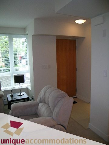Furnished living room with a cozy armchair and a small table, natural light from the window. - 184 Chesterfield Avenue, North Vancouver