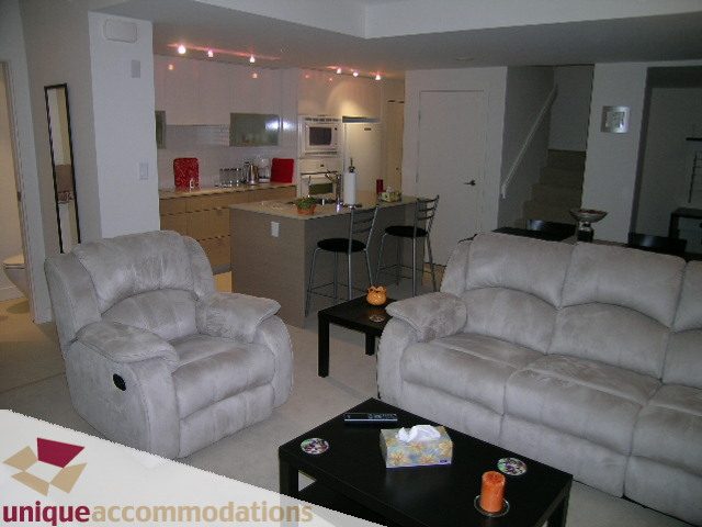 Bright living room with plush furniture, modern kitchen with granite countertops, and a cozy den area. - 184 Chesterfield Avenue, North Vancouver