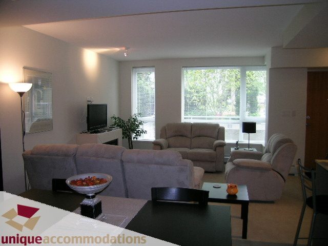 Furnished living room with modern furniture, large windows, and a cozy ambiance. - 184 Chesterfield Avenue, North Vancouver