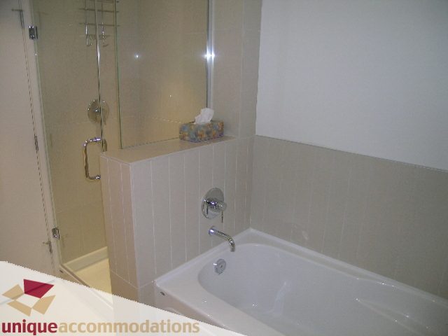 Bathroom with modern fixtures, glass shower, and white tub. - 184 Chesterfield Avenue, North Vancouver