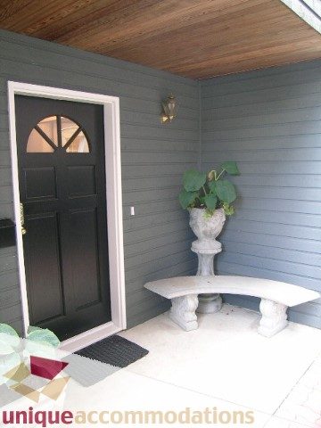 Front porch with dark door, potted plant, and stone bench. - 1815 Creelman Avenue, Vancouver West Side