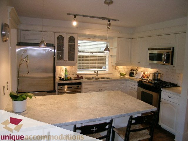 Bright kitchen with marble countertops, stainless steel appliances, and a central island. - 1815 Creelman Avenue, Vancouver West Side