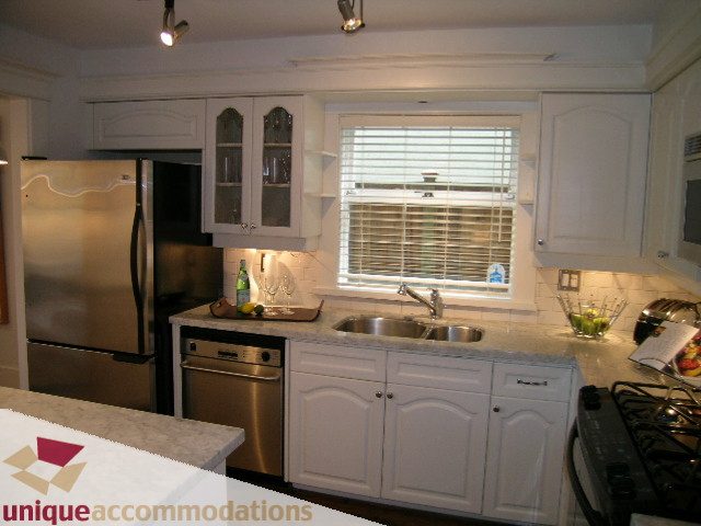 Bright kitchen with white cabinets, stainless steel appliances, and a window above the sink. - 1815 Creelman Avenue, Vancouver West Side