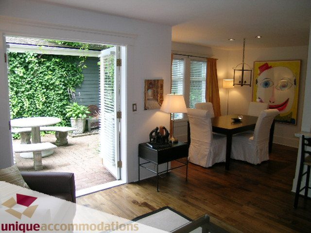 Furnished living room with hardwood floors, large windows, and a vibrant abstract painting. - 1815 Creelman Avenue, Vancouver West Side