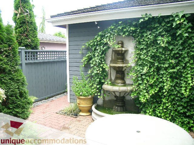 Furnished patio with ivy-covered wall and fountain, brick patio. - 1815 Creelman Avenue, Vancouver West Side