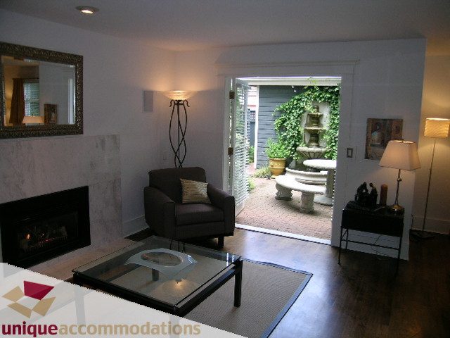 Spacious living room with hardwood floors, glass coffee table, and fireplace. - 1815 Creelman Avenue, Vancouver West Side