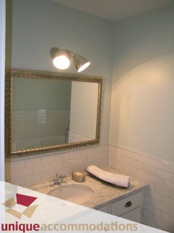Furnished bathroom with white subway tiles and a marble countertop. - 1815 Creelman Avenue, Vancouver West Side