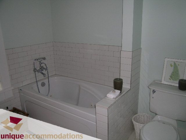 Bathroom with white subway tile, modern sink, and wicker trash bin. - 1815 Creelman Avenue, Vancouver West Side