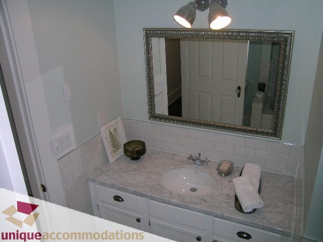 Bathroom with marble countertop and framed mirror. - 1815 Creelman Avenue, Vancouver West Side