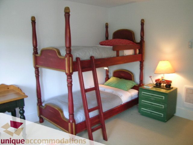 Bright bedroom with bunk beds, wooden furniture, and a small nightstand. - 1815 Creelman Avenue, Vancouver West Side