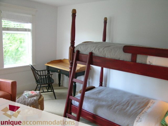 Bright bedroom with wooden bunk beds and a window view. - 1815 Creelman Avenue, Vancouver West Side
