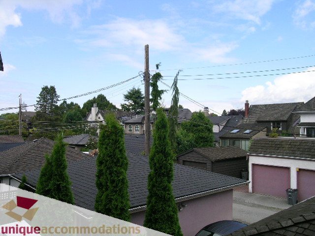Furnished living room with city view and tall evergreen trees. - 1815 Creelman Avenue, Vancouver West Side