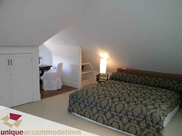Bright bedroom with patterned bedding and wooden floors. - 1815 Creelman Avenue, Vancouver West Side