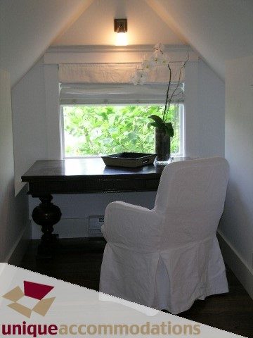 Dining area with white slipcovered chairs and a window with greenery outside. - 1815 Creelman Avenue, Vancouver West Side