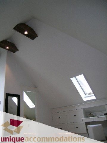 Bright bedroom with slanted ceiling, skylights, and white furniture. - 1815 Creelman Avenue, Vancouver West Side