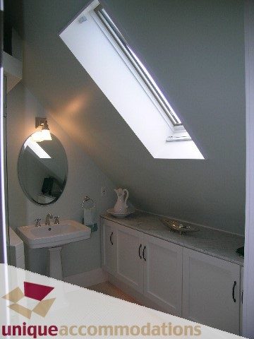 Bright bathroom with white cabinets and a skylight. - 1815 Creelman Avenue, Vancouver West Side