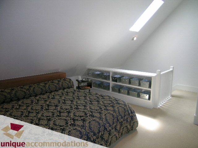 Bright attic bedroom with patterned carpet and built-in shelving. - 1815 Creelman Avenue, Vancouver West Side