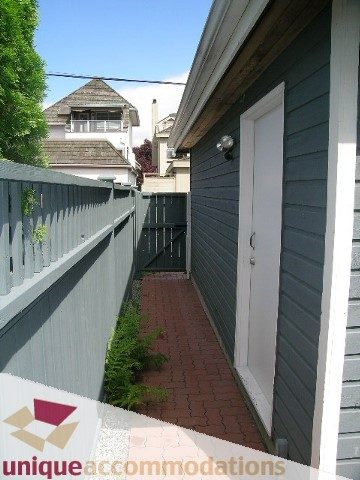 Furnished patio with brick flooring and greenery, leading to a white door. - 1815 Creelman Avenue, Vancouver West Side