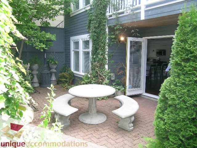 Furnished patio with brick flooring, ivy-covered walls, and a central table with benches. - 1815 Creelman Avenue, Vancouver West Side