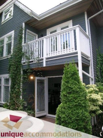 Furnished balcony with white railings and green ivy, surrounded by lush greenery. - 1815 Creelman Avenue, Vancouver West Side