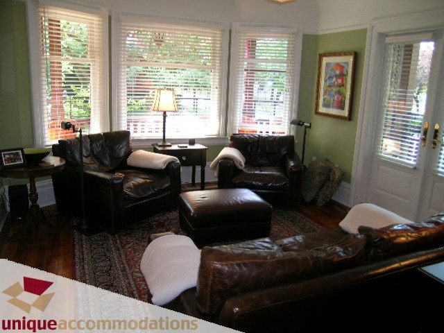 Furnished living room with leather sofas, hardwood floors, and large windows. - 995 Bute Street "Rand House", Vancouver Downtown