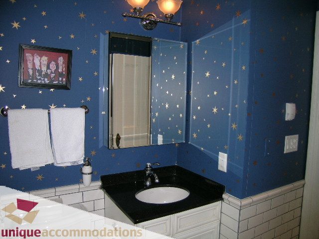 Furnished bathroom with star-patterned walls, black countertop, and white towels. - 995 Bute Street "Rand House", Vancouver Downtown