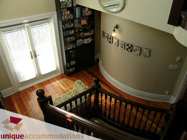 Furnished living area with hardwood floors, bookshelf, and wall art. - 995 Bute Street "Rand House", Vancouver Downtown