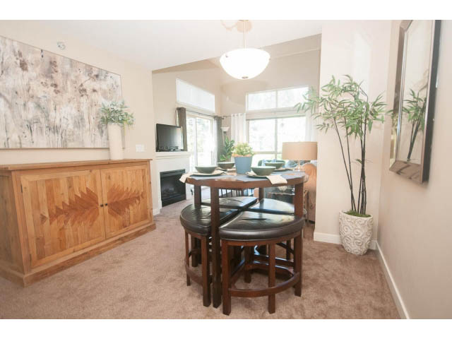 Furnished dining area with wooden furniture and large windows, natural light, and artwork on the wall. - 418 - 1633 Mackay Avenue, North Vancouver