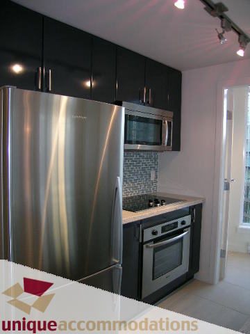 Bright kitchen with stainless steel appliances and black cabinets. - 1101 - 1188 West Pender, Vancouver Downtown