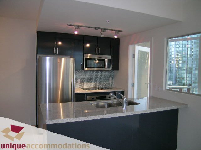 Bright kitchen with granite countertops and stainless steel appliances, showcasing a city view. - 1101 - 1188 West Pender, Vancouver Downtown