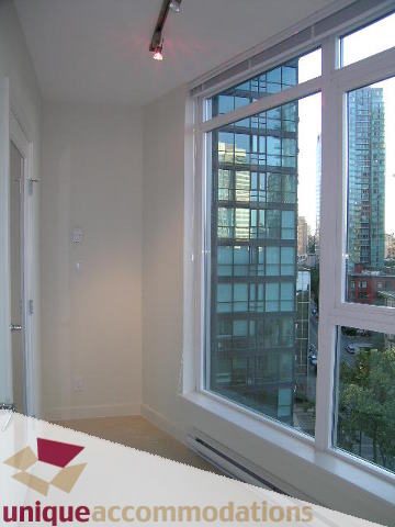 Bright living room with large windows showcasing city views, hardwood floors, and modern decor. - 1101 - 1188 West Pender, Vancouver Downtown