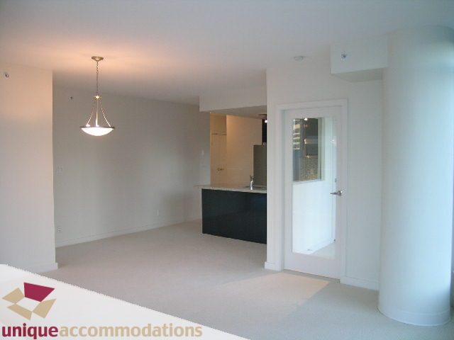 Spacious living room with white walls, modern chandelier, and open-concept layout. - 1101 - 1188 West Pender, Vancouver Downtown