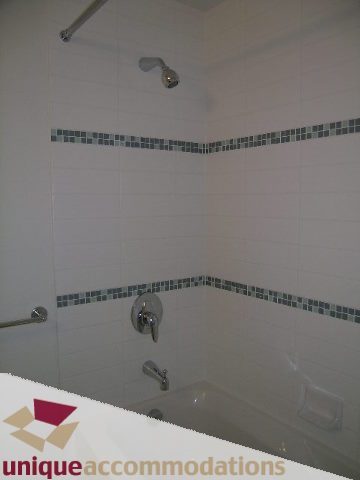 Bright bathroom with white tiles and mosaic accent strip. - 1101 - 1188 West Pender, Vancouver Downtown