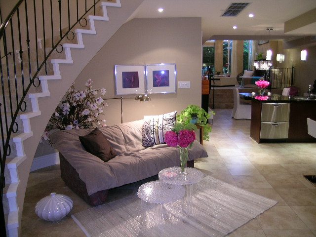 Living room with modern decor, glass coffee table, floral arrangements, and spiral staircase. - 202 -1280 Richards Street, Vancouver Downtown