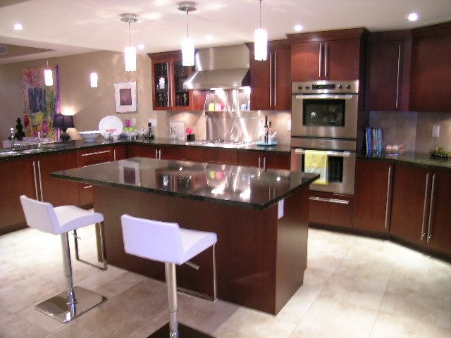 Modern kitchen with dark wood cabinets, stainless steel appliances, and granite countertops. - 202 -1280 Richards Street, Vancouver Downtown