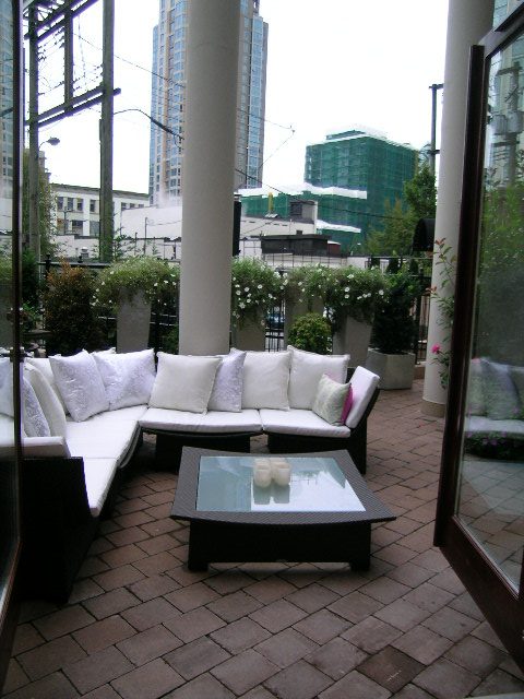 Outdoor patio with modern furniture, brick flooring, and cityscape view. - 202 -1280 Richards Street, Vancouver Downtown