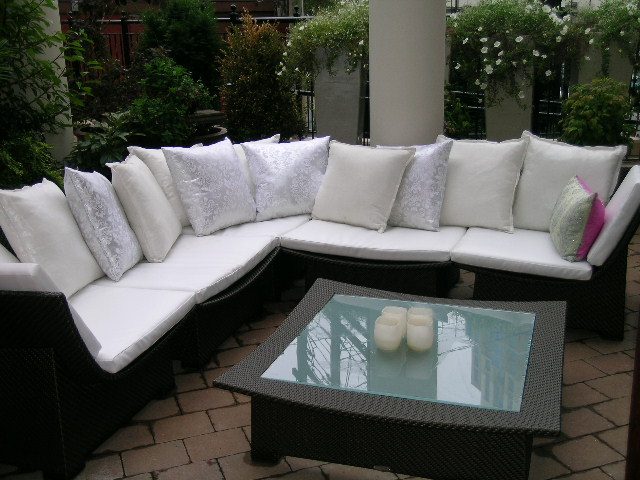 Outdoor patio with white sectional sofa, glass coffee table, and potted plants. - 202 -1280 Richards Street, Vancouver Downtown